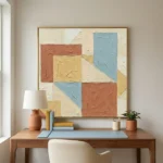 Textured abstract hand-painted canvas in terracotta, cream, and soft blue geometric blocks, modern workspace
