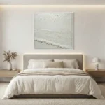 Minimalist textured hand-painted canvas depicting serene seascape with soft horizons in monochromatic white and cream tones, modern bedroom