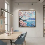 Impressionist hand-painted canvas depicting Mount Fuji framed by blooming cherry blossoms in pink and turquoise, contemporary workspace