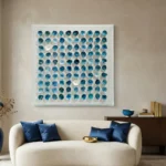 Abstract hand-painted canvas featuring circular forms in layered teal and cream tones, contemporary living space