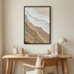 Contemporary landscape hand-painted canvas depicting coastal waves and sand patterns in cream and taupe tones, styled workspace