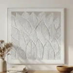 Textured minimalist hand-painted canvas featuring layered botanical leaves in monochrome white and cream, contemporary interior