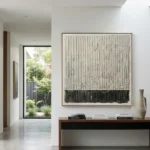 Minimalist hand-painted canvas in monochromatic charcoal and cream with vertical linear abstraction, contemporary living space