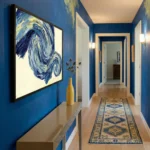 Gestural abstract expressionist hand-painted canvas in swirling navy and gold brushstrokes, hallway setting