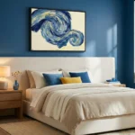 Gestural abstract hand-painted canvas with swirling cobalt and golden brushstrokes on cream, modern bedroom setting