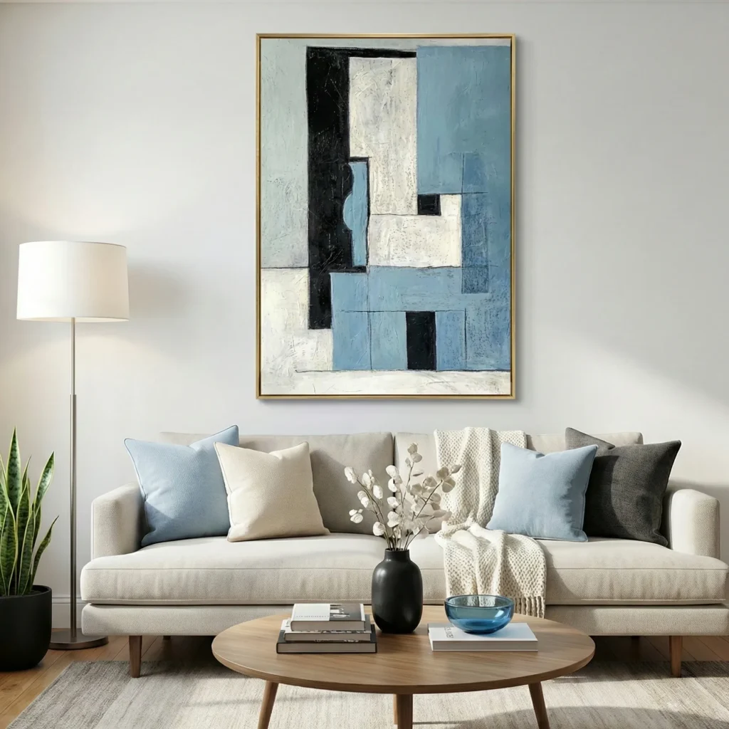 Layered abstract hand-painted canvas in blue, cream, and black geometric forms, contemporary living space