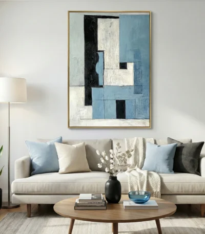 Layered abstract hand-painted canvas in blue, cream, and black geometric forms, contemporary living space