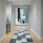 Layered abstract hand-painted canvas in blue, black, and cream geometric blocks, modern hallway