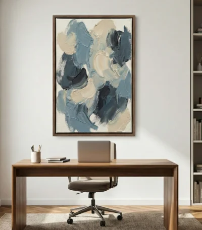 Gestural abstract hand-painted canvas in layered blue, cream, and charcoal brushstrokes, contemporary workspace