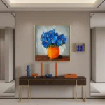 Gestural hand-painted canvas of vibrant blue flowers in orange vase with expressive brushwork, blue and orange palette, contemporary entryway