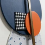 Textured abstract hand-painted canvas with geometric circles and houndstooth pattern in navy, orange, and cream tones