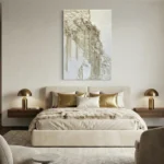 Textured abstract hand-painted canvas in cream and gold tones with layered botanical elements, contemporary bedroom setting