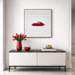 Minimalist hand-painted canvas depicting a solitary red car against white textured brushstrokes, contemporary living space