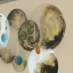 Contemporary abstract hand-painted canvas with organic forms, scrollwork motifs, jewel-tone accents in cream and sage tones