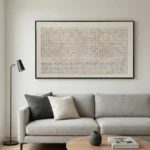 Minimalist textured hand-painted canvas with geometric grid pattern and vertical text elements in cream and charcoal, contemporary living space