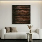 Textured abstract hand-painted canvas in layered earth tones and charcoal, contemporary living space