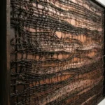 Textured abstract hand-painted canvas in deep charcoal and burnt sienna tones with layered crocodile-skin brushwork, contemporary interior