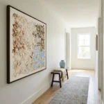 Textured abstract hand-painted canvas in cream, taupe, and soft blue organic forms, contemporary hallway
