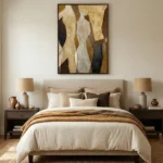 Layered abstract hand-painted canvas in warm golds, creams, and deep browns with organic flowing forms, modern bedroom setting