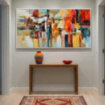 Gestural abstract expressionist hand-painted canvas in vibrant orange, red, yellow and teal brushstrokes, contemporary entryway
