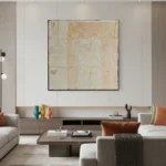Textured abstract hand-painted canvas in cream and soft ochre with gestural layered brushstrokes, contemporary living space