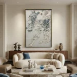 Textured hand-painted canvas depicting layered wisteria branches in cream, white, and soft blue tones, contemporary living space