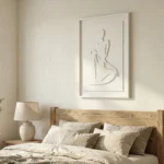 Minimalist hand-painted canvas depicting an abstract seated female figure in cream and taupe tones, modern bedroom