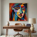 Cubist hand-painted canvas depicting a fragmented face in bold primary colors and geometric sections, contemporary workspace