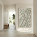 Textured abstract hand-painted canvas with interlocking diagonal lines in cream and grey tones, contemporary hallway