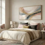 Textured abstract hand-painted canvas with sweeping gold and charcoal brushstrokes in cream and ochre tones, modern bedroom setting