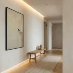 Minimalist hand-painted canvas featuring a solitary black bird perched on textured earth tones, contemporary hallway