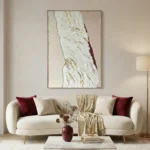 Textured abstract hand-painted canvas with cream and gold gestural brushstrokes accented by deep burgundy, contemporary living space