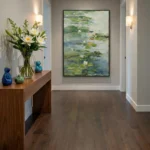 Impressionist hand-painted canvas depicting water lilies in soft greens, whites and blues, contemporary hallway setting