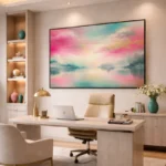 Impressionist hand-painted canvas depicting misty lakeside landscape in soft pink, turquoise, and cream tones, modern office setting
