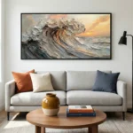 Textured impressionist seascape painting depicting a dramatic rolling wave at sunset in warm ochre and silvery-grey tones, hand-painted canvas in contemporary living space