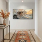 Textured impressionist seascape painting depicting dramatic ocean waves at sunset in warm ochre and grey tones, contemporary entryway