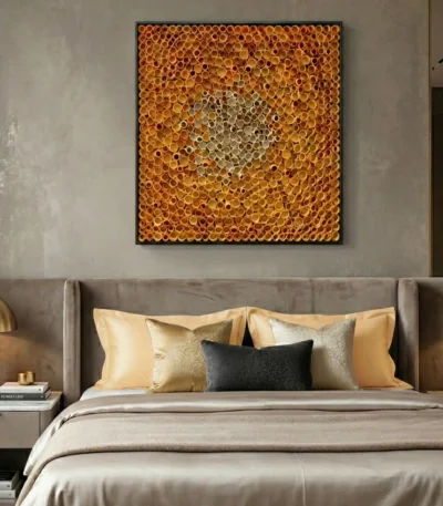 Textured abstract hand-painted canvas in warm golden and amber tones with layered circular motifs, modern bedroom setting