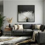 Layered abstract expressionist hand-painted canvas in charcoal, cream, and gold with gestural brushwork, contemporary living space