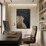 Textured abstract hand-painted canvas in charcoal and gold leaf with organic erosion effect, contemporary office space