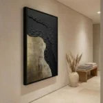 Textured abstract hand-painted canvas in charcoal and gold leaf with layered gestural marks, contemporary entryway