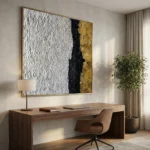 Textured abstract hand-painted canvas with white stippled texture, black vertical stripe, and gold leaf accents, contemporary workspace