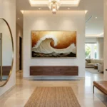Textured contemporary hand-painted canvas depicting a dynamic ocean wave in cream and burnt sienna tones, modern entryway