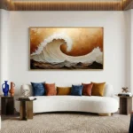 Textured abstract hand-painted canvas depicting a cresting wave in cream and bronze tones, contemporary living space