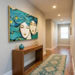 Contemporary figurative hand-painted canvas depicting two serene faces with flowing turquoise hair and gold accents, modern hallway