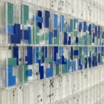 Contemporary abstract wall art with layered geometric rectangles in navy, sky blue and seafoam green tones, hand-painted canvas in modern gallery setting