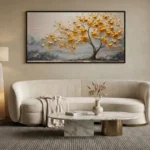 Textured hand-painted canvas depicting golden tree with layered foliage in cream and charcoal tones, contemporary living space