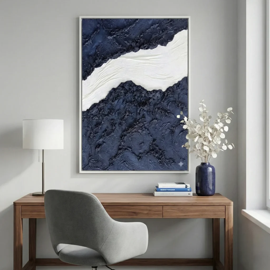 Textured abstract hand-painted canvas in deep navy and cream with gestural brushwork, modern workspace