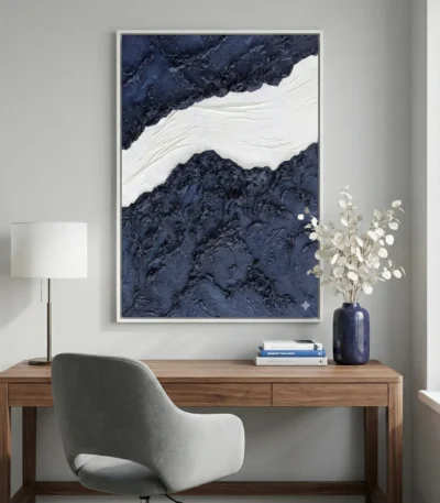 Textured abstract hand-painted canvas in deep navy and cream with gestural brushwork, modern workspace