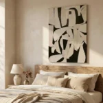 Abstract hand-painted canvas with bold black and cream geometric shapes, layered in contemporary bedroom setting