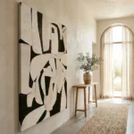 Gestural abstract hand-painted canvas in monochromatic black and cream, bold organic shapes, contemporary entryway